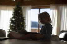 a child reading a book at Christmas 