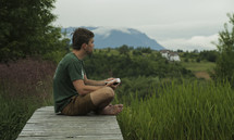 a man reading outdoors with a scenic view 