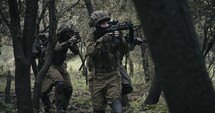 Squad of fully armed commando soldiers during combat in a forest scenery