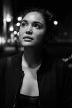 face of a young woman standing outdoors at night 