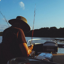 an man fishing in a boat 