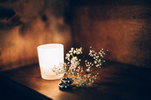 flowers, candle, and wedding bands on a nightstand 