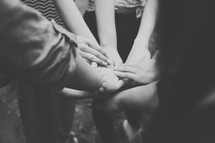 A group of girls are united as they put their hands together.