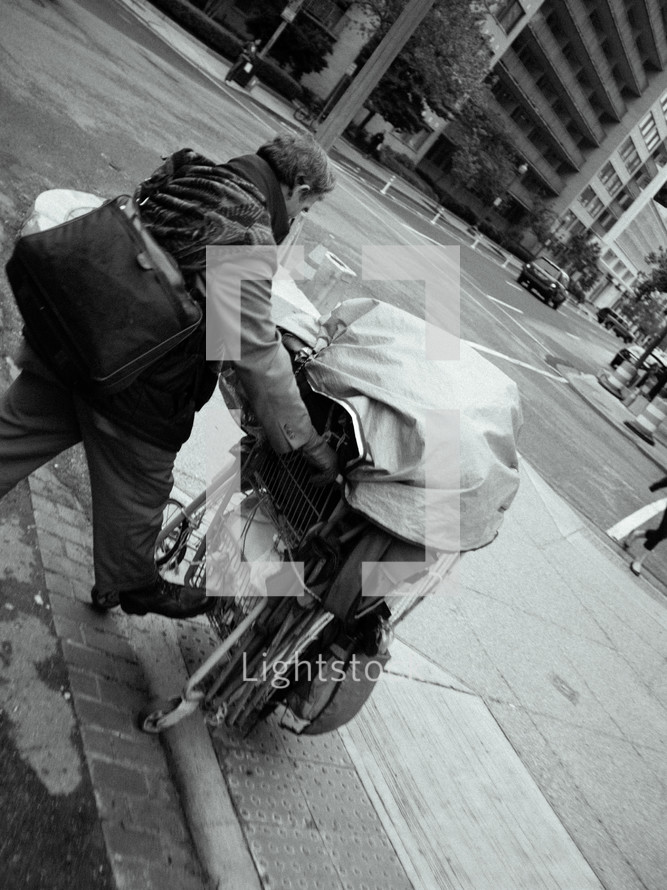 homeless man pushing a shopping cart 