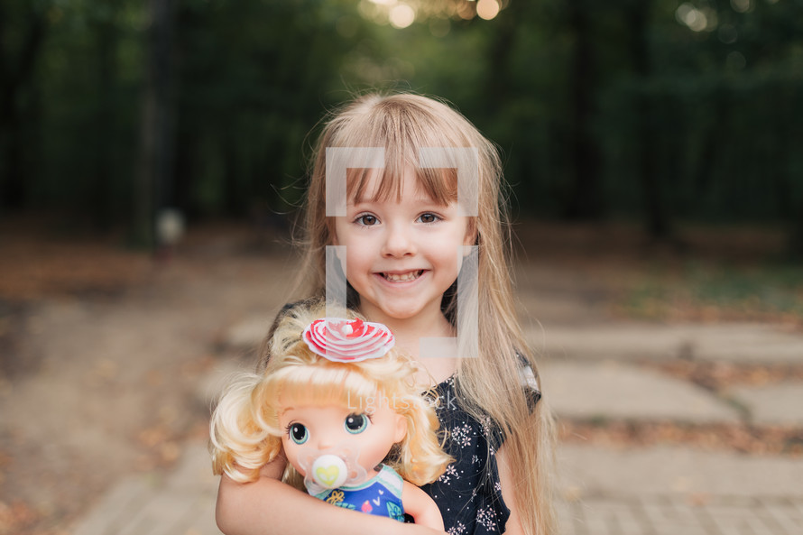 smiling girl holding a doll 