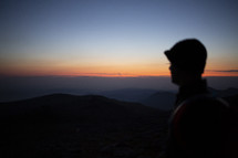 silhouette of a man on a mountaintop at dawn 