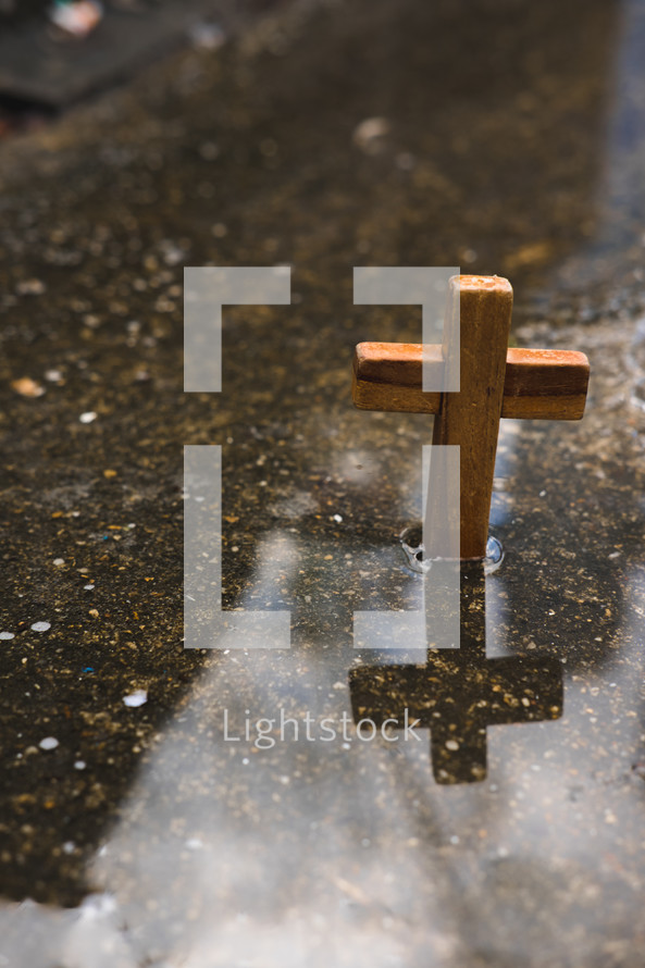 wooden cross in a puddle 