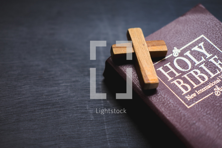 small wooden cross on the cover of a Bible 