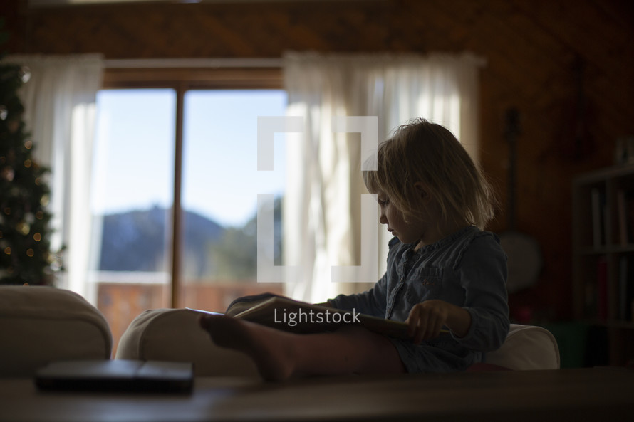 a child reading a book at Christmas 