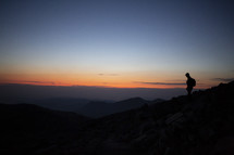 silhouette of a man on a mountaintop at dawn 