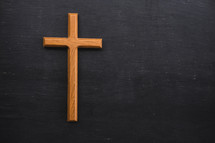 wood cross on black background 