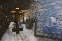 a wooden cross in a puddle 