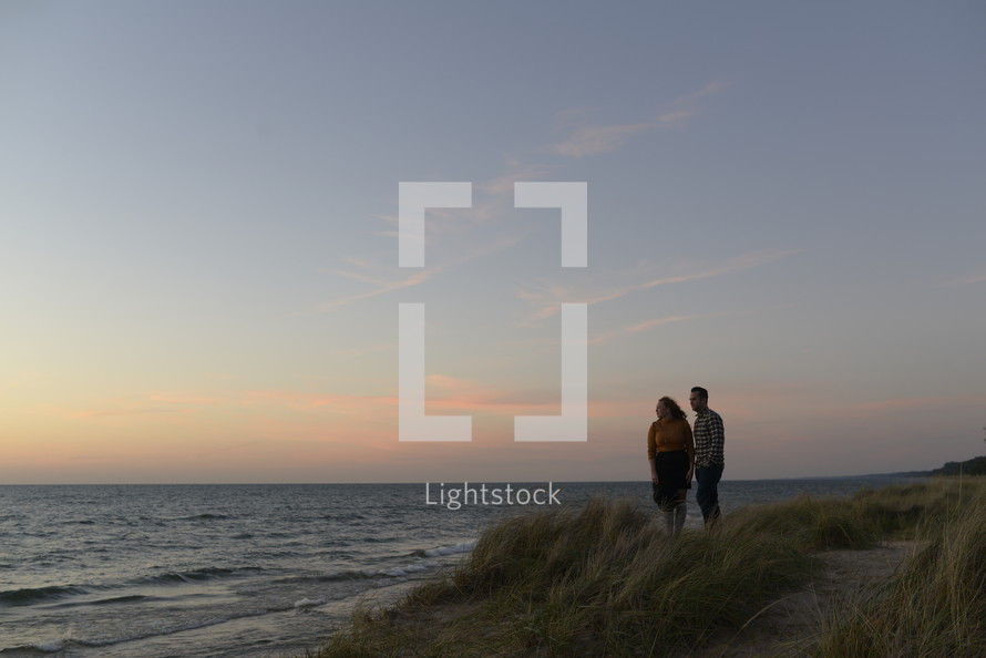 couple standing on a beach in the evening in fall 