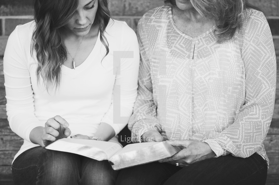 Mother and daughter reading a Bible together 