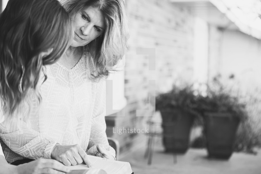 A mother and daughter reading a Bible together 