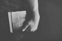man holding a Bible at his side 
