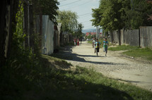 children running on a dirt road in a poor village 