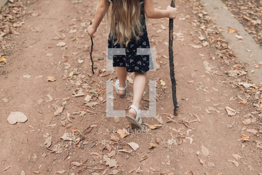 girl playing with sticks 