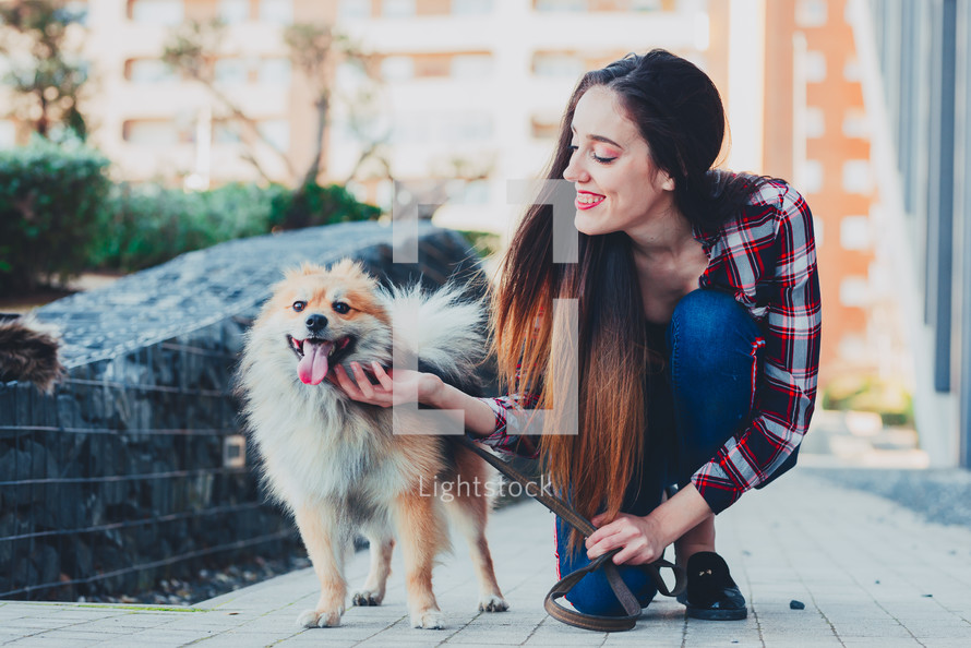 a woman petting a small dog 
