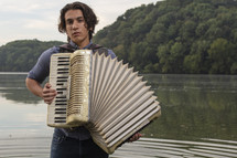 a man standing in a lake playing an accordion 