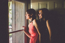 Women looking out a window in excitement. 