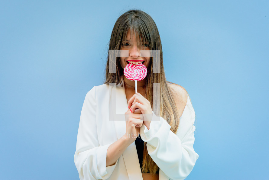 a woman biting a lollipop 