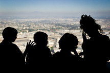 silhouettes of children looking out a window 