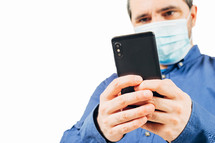 man in medical mask looking at smartphone on white background
