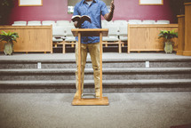 a man reading from a Bible in church 