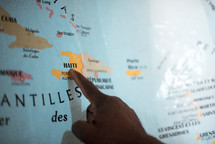 pointing a finger to Haiti on a map 