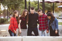 friends praying together outdoors 