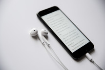 earbuds and Bible app on a cellphone screen 