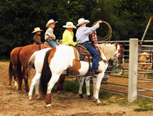A group of young rodeo cowboys on horseback practicing their roping and riding skills at a rodeo in Central Florida where young cowboys and ranchers can practice and learn the skills to become cowboys. 