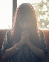 woman with head bowed in prayer 