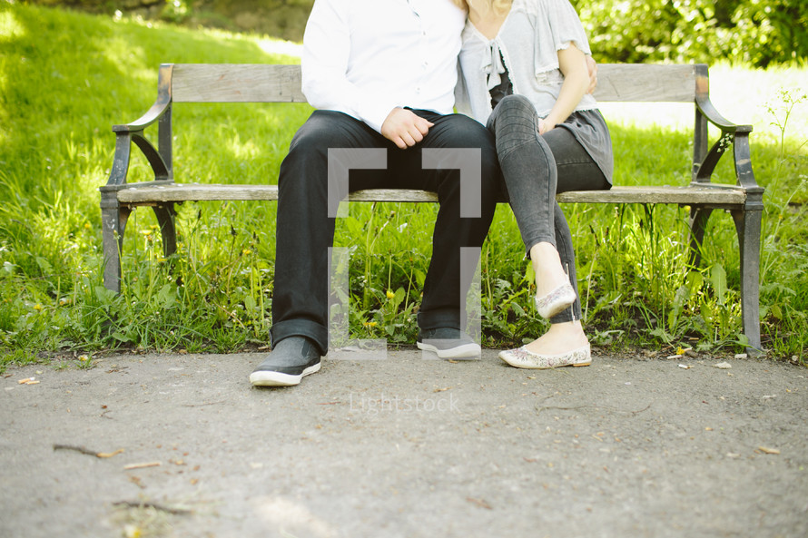 couple snuggling on a bench