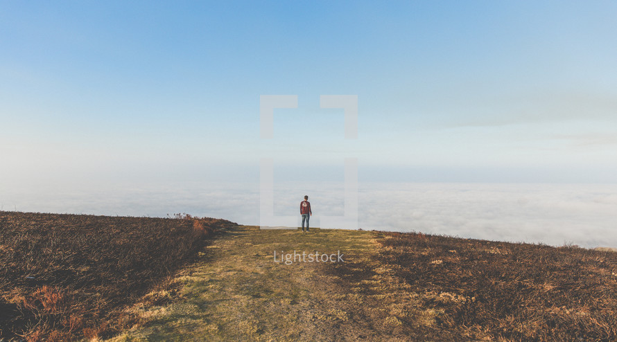 a man standing on a mountaintop above the clouds 