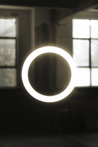 Floating halo ring light in and industrial warehouse building, abstract light photography