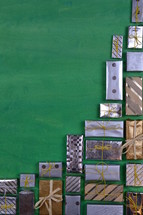 many little silver and golden presents building a border on green wooden background