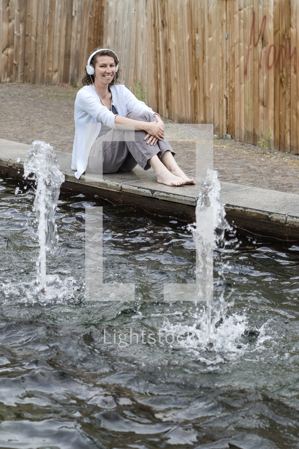 woman sitting by a reflection pool thinking 