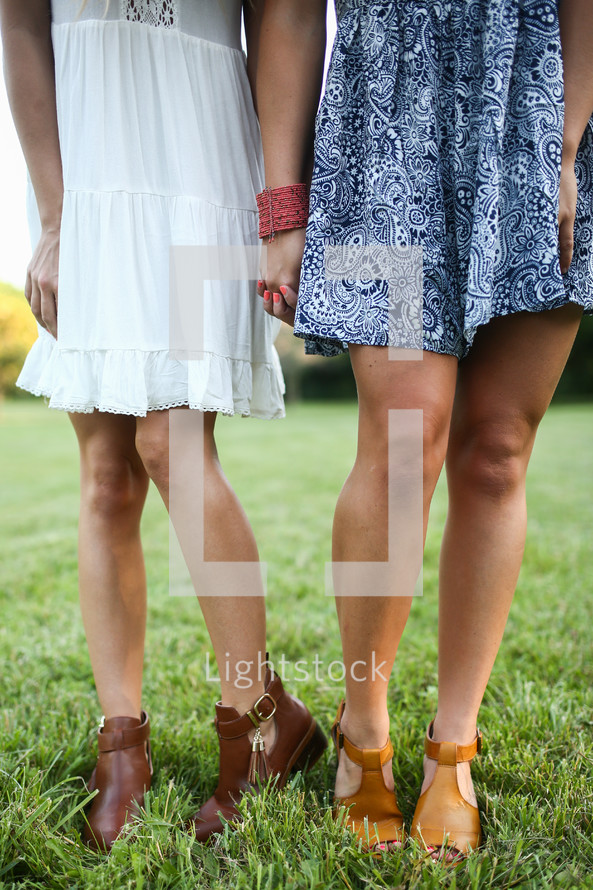 legs of young women wearing summer dresses 