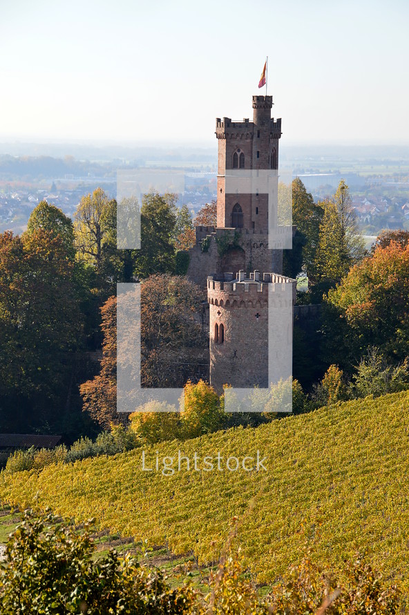 towers of a fortified castle in the middle of a vineyard in autumn. 