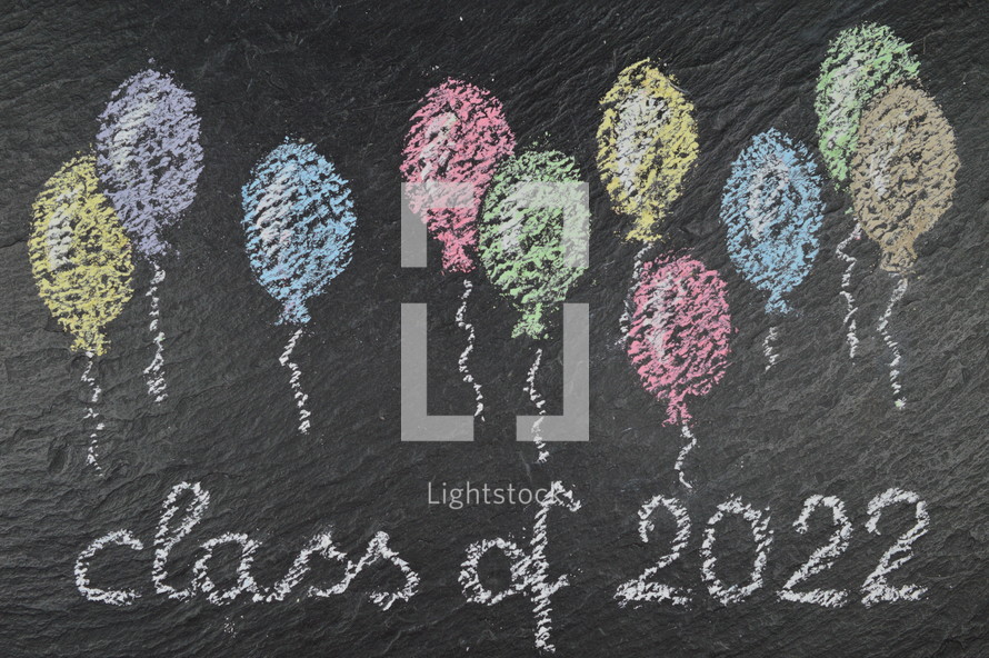chalk on slate with balloons and the words: class of 2022