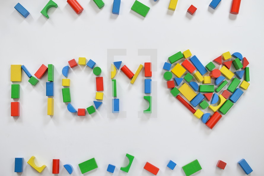 wooden blocks in the shape of a heart and the word mom 