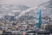 Snowy city and glass skyscraper