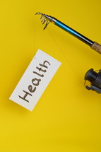 A fishing pole with a piece of paper with the word health on it 