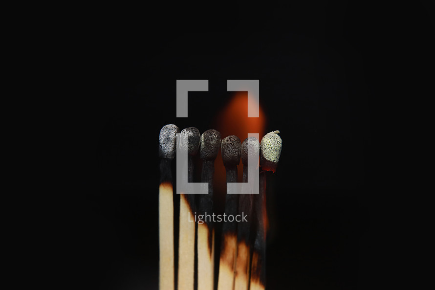 Burning matches on black background. matchsticks on fire in row of burning is sequence while one match stay down from burning to avoid fire connecting against black background