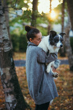 Woman carrying her dog on a walk