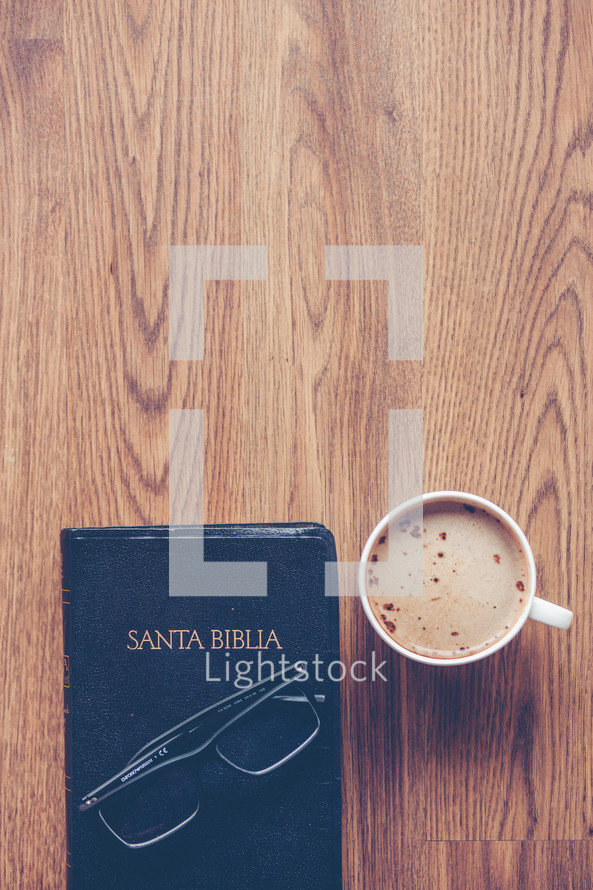 Santa Biblia, reading glasses, and cappuccino