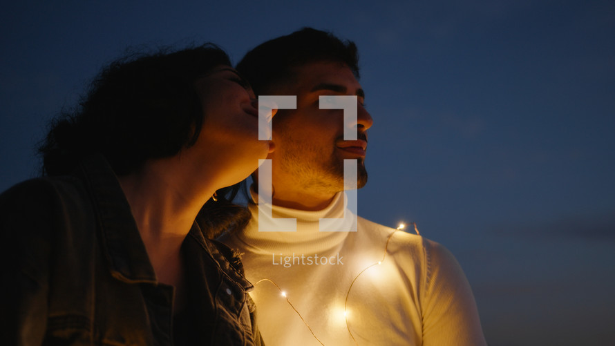 Couple kiss in the night outdoor with lights
