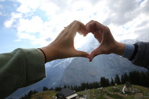 heart shape with hands and mountain 